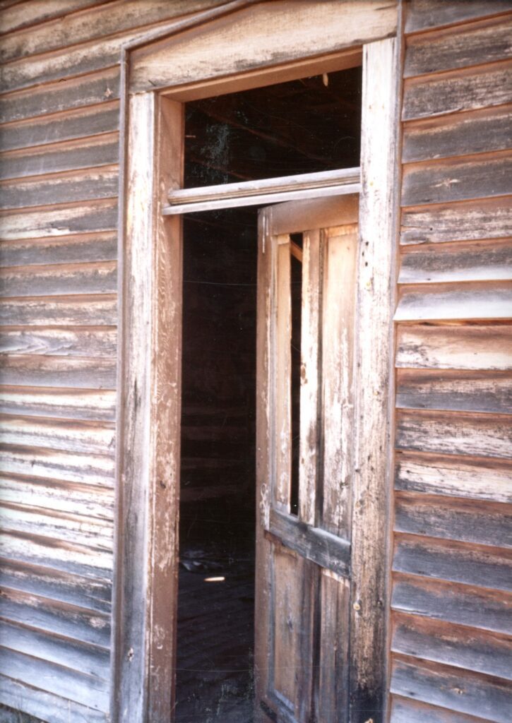 Wooden open door set in old building doorway.